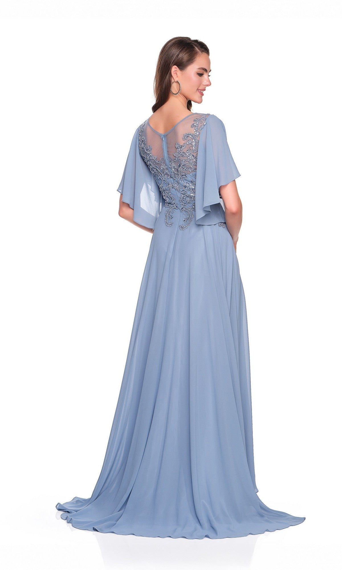 A woman stands against a white background wearing the Dave & Johnny Long Prom Dress 11676—a floor-length, light blue A-line gown with sheer cape sleeves and embroidered back detailing.